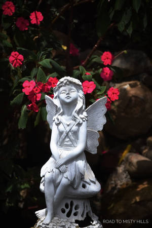 Majestic Angel Statue In Tranquil Setting Wallpaper
