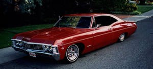 Majestic Red 1967 Chevrolet Impala Showcasing Vintage Beauty Wallpaper