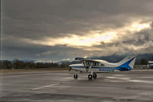 Majestic Small Airplane Resting On Airport Ground Wallpaper