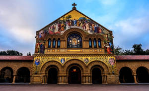 Majestic Stanford University Church Under A Vibrant Blue Sky Wallpaper