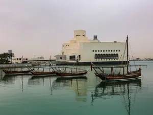 Majestic View Of The Museum Of Islamic Art With Serene Boats In The Forefront, Doha, Qatar. Wallpaper