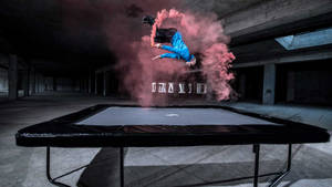 Man Doing An Acrobat On A Trampoline With Smoke Wallpaper