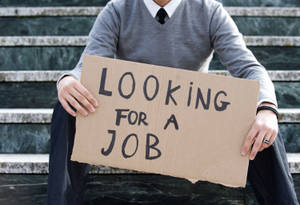 Man Holding Signage Related To Unemployment Wallpaper