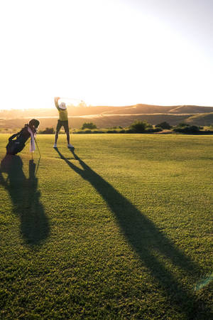 Man Playing On Golf Course During Sunset Wallpaper