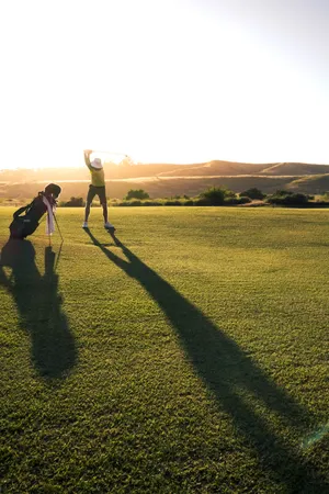 Man Playing On Golf Course During Sunset Wallpaper