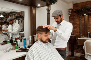 Man Wearing Newsboy Hat Performs Haircut Wallpaper