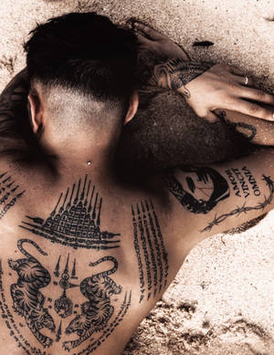 Man With Hd Tattoo On Sand Wallpaper