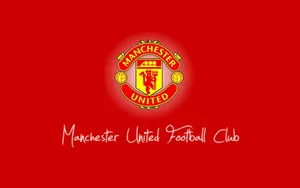 Manchester United Iconic Team Crest Passionately Illustrated On A Vibrant Red Background. Wallpaper