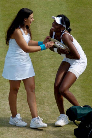 Marion Bartoli And Venus Williams During A Tennis Match. Wallpaper