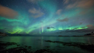 Marvel At The Beauty Of The Green Aurora Borealis In The Night Sky Wallpaper