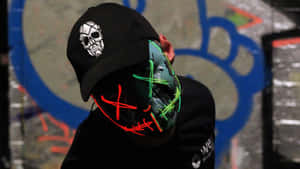 Masked Man With A Black Cap With Skull Logo Wallpaper