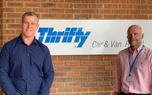 Men With Thrifty Car Rental Sign Wallpaper