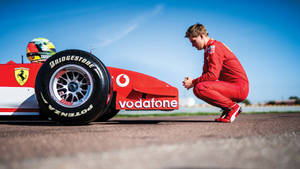 Mick Schumacher Crouching Beside A Car Wallpaper