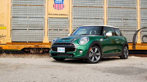 Mini Green Car Outside Gold Building Wallpaper