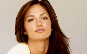 Minka Kelly Striking A Pose Against A Grey Background Wallpaper