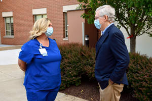 Mitch Mcconnell Engaged In Conversation With A Healthcare Professional Wallpaper