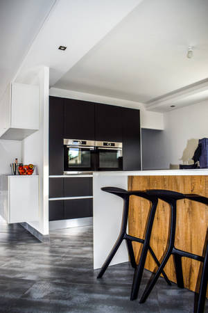 Modern Kitchen With Sleek Design And Black Stools Wallpaper