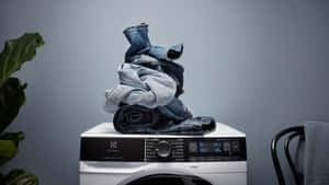 Modern Washing Machine With Stacked Jeans Wallpaper