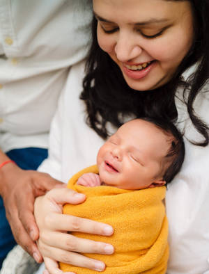 Mother And Baby In Yellow Swaddle Wallpaper