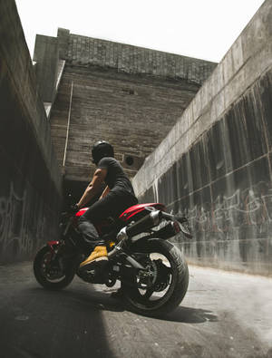 Motorcyclist Posing Between Concrete Walls Wallpaper