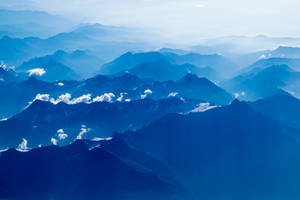 Mountain Ranges Under A Beautiful Blue Sky Wallpaper