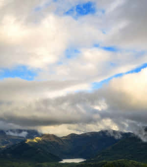 Mountainous_ Landscape_with_ Lake_and_ Clouds.jpg Wallpaper