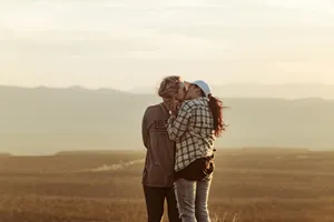 Mujeres Lesbianas Kissing In Open Area Wallpaper