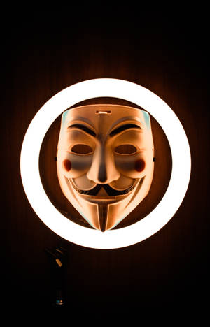Mysterious Hacker In Mask Illuminated By Ring Light Wallpaper