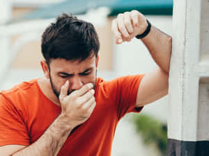 Nauseous Man In Orange Shirt Wallpaper