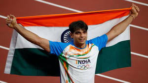 Neeraj Chopra With Indian Flag After His Victorious Olympic Win Wallpaper