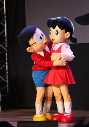 Nobita Shizuka Love With Mascots Hugging Wallpaper