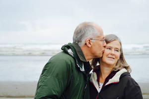 Old Couple Kiss By The Beach Wallpaper