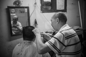Old Man Performing Haircut Wallpaper