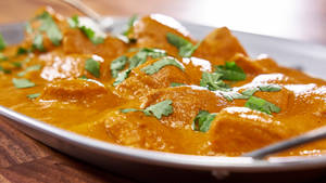 Orange Colored Butter Chicken Dish Wallpaper