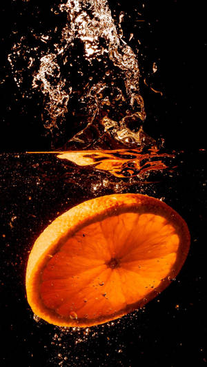 Orange Fruit Dropped In Water Wallpaper