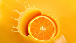 Orange Fruit Dunked In Juice Wallpaper