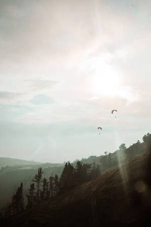 Paragliding Above Mountain Slope Wallpaper