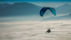 Paragliding Above Thick Clouds Wallpaper