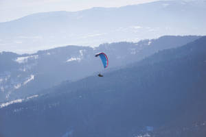 Paragliding Over Mountain Ranges Wallpaper
