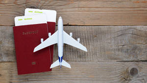 Passport And Airplane Toy On Table Wallpaper