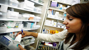 Pharmacist Checking A Medicine Bottle Wallpaper