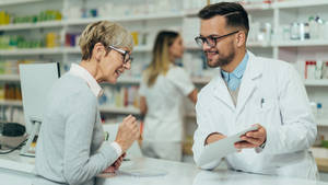 Pharmacist Explaining To Old Woman Wallpaper