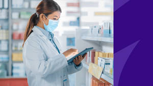Pharmacist Wearing Mask Holding Tablet Wallpaper