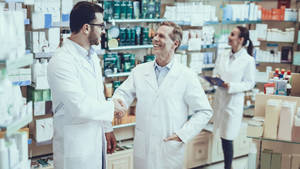Pharmacists Forming A Professional Connection Through Handshake Wallpaper