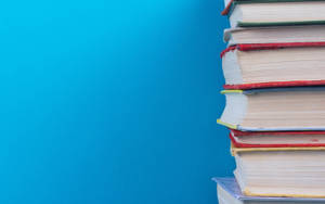 Pile Of Books On Blue Background Wallpaper