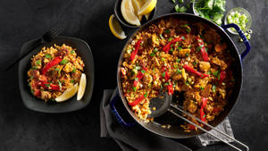 Plate And Pot Of Spicy Paella Wallpaper