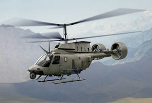 Powerful Military Helicopter Showcasing Its Heavy Cannon Wallpaper