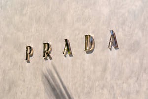 Prada Gold Letters On Wall Wallpaper