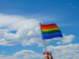Pride_ Flag_ Waving_ Against_ Blue_ Sky Wallpaper