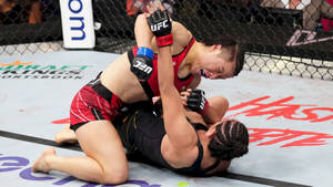 Professional Mma Fighter, Zhang Weili, In Intense Fighting Action Against An Opponent. Wallpaper